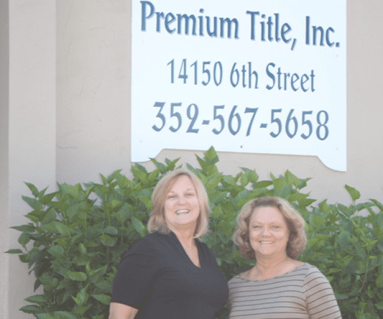Sharon and Jeanie standing under Premium Title Inc. sign in Dade City, FL